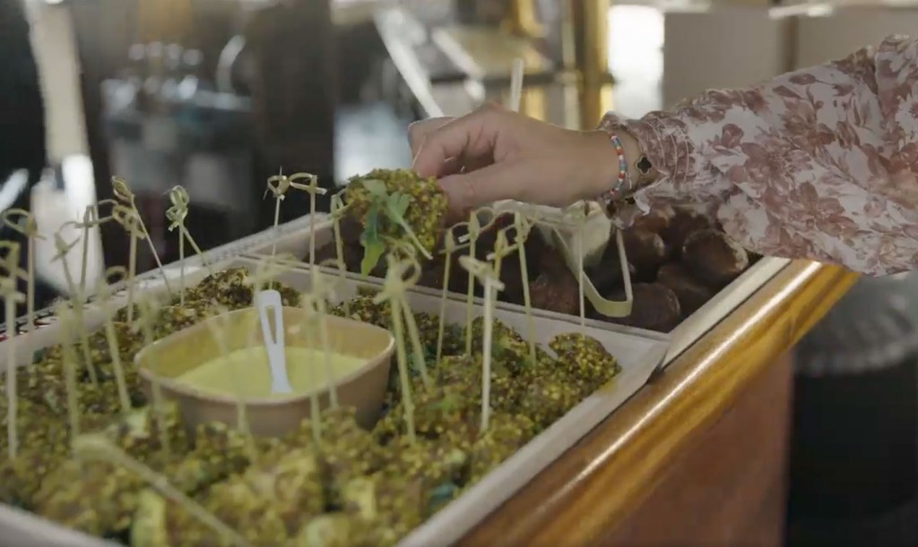 A person holding a tray of food at the Botanist Office Catering